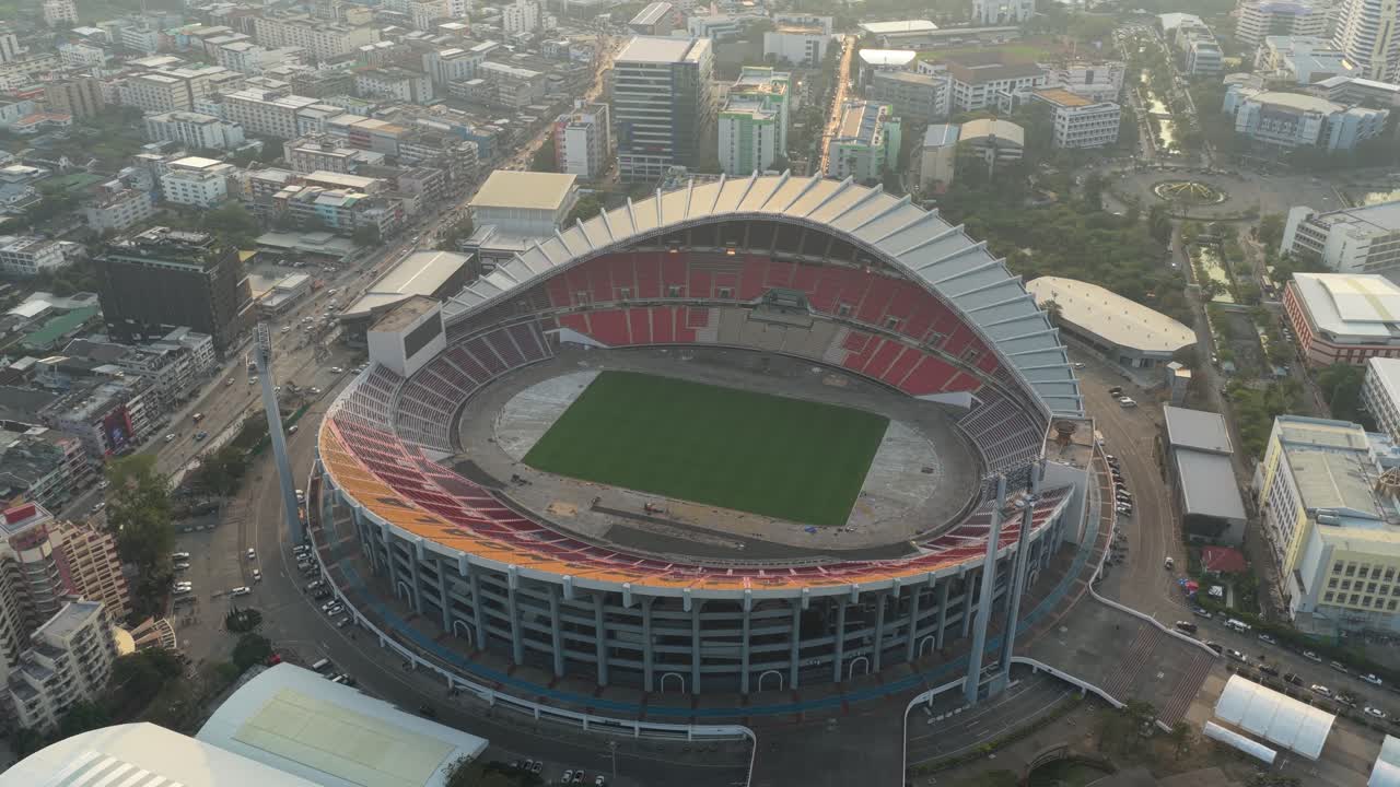 Impresionante perspectiva aérea del Estadio Nacional Rajamangala en Bangkok, Tailandia, mostrando su imponente arquitectura y el paisaje urbano circundante