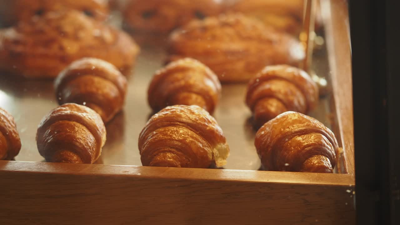 Golden croissants in a bakery display case