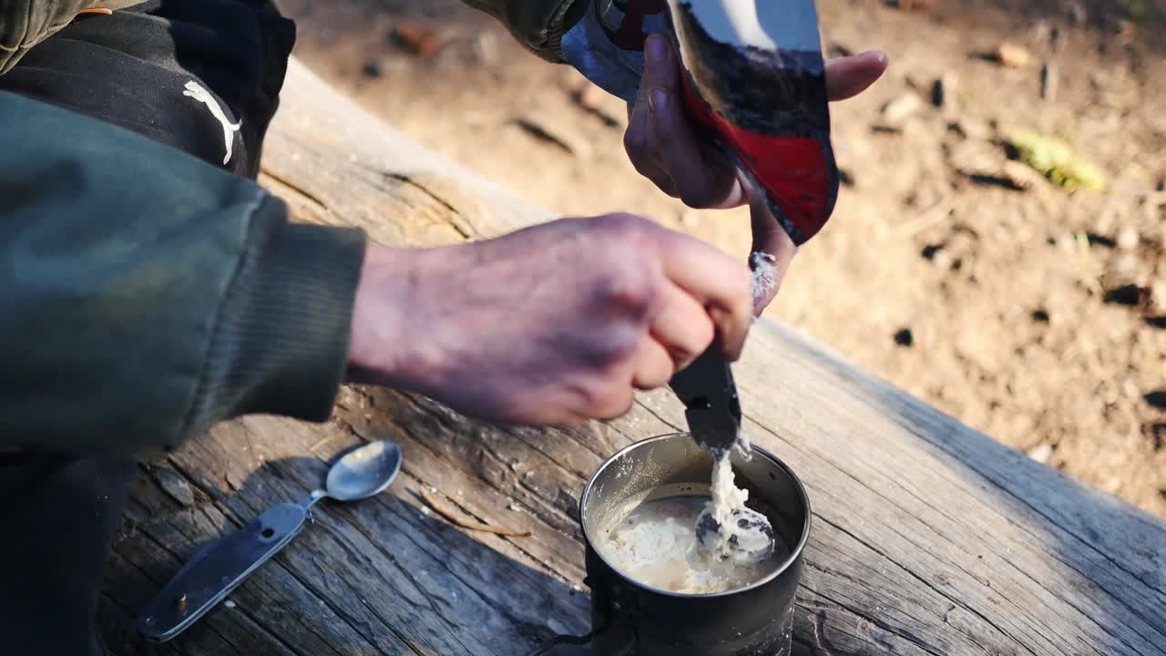 Backpacker serving campfire meal