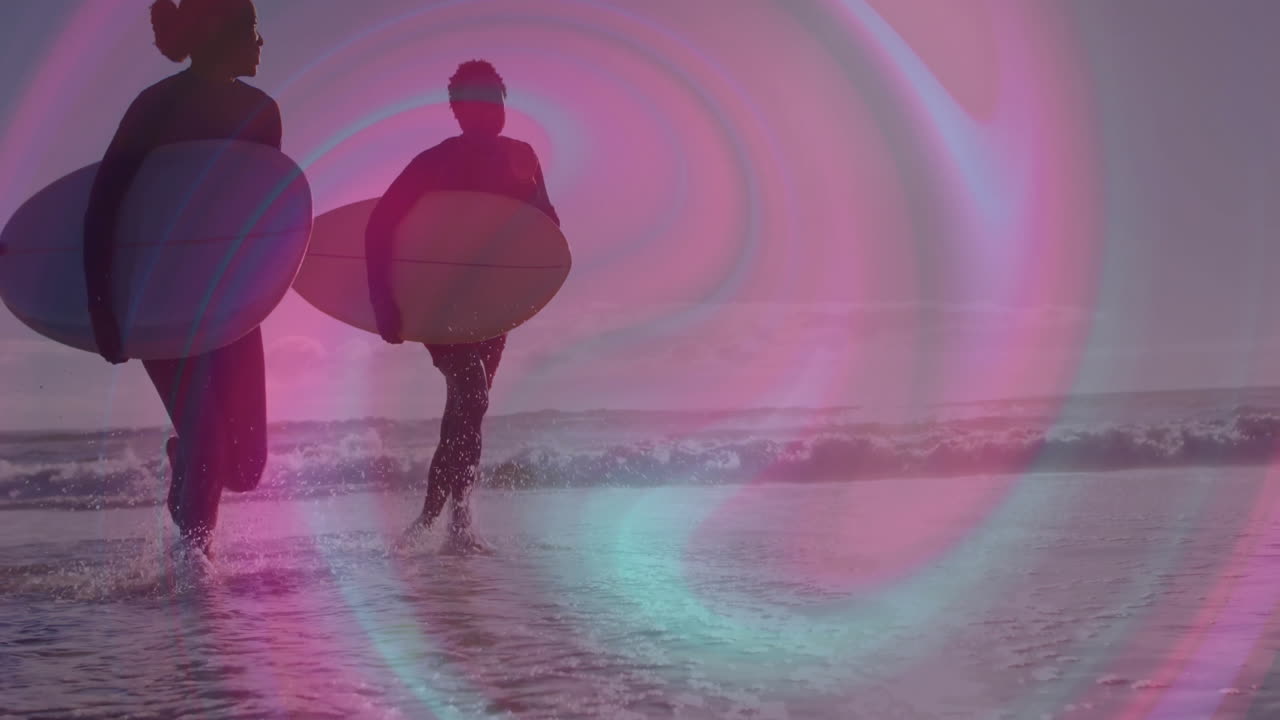 Surfers running into shallow water at sunset, using pink purple lens-flare for marketing animation