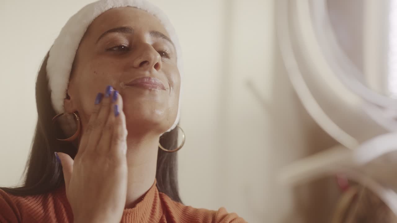 Woman applies skincare product to her face