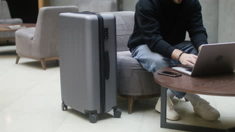 junger mann mit laptop in der hotelhalle