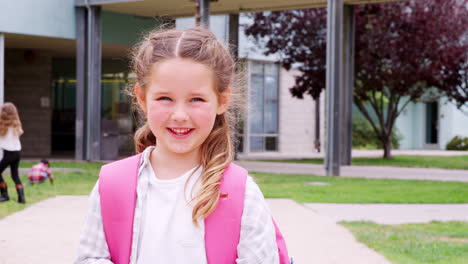 elementary schoolgirl looking  to camera smiling, outdoors