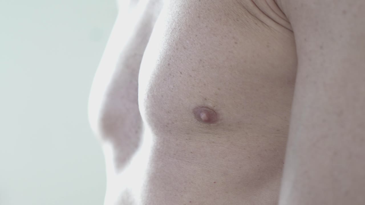 Close-up shot of a muscular male athlete revealing his pectoralis muscles