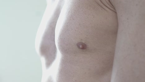 fotografía en primer plano de un atleta masculino musculoso revelando sus músculos pectorales