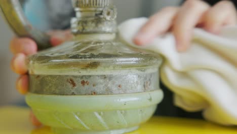 close up of hands cleaning an old gas lamp