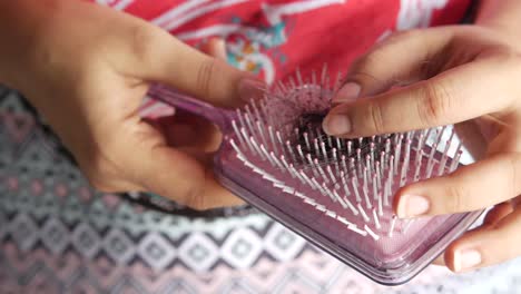 woman holding a hairbrush with hair loss