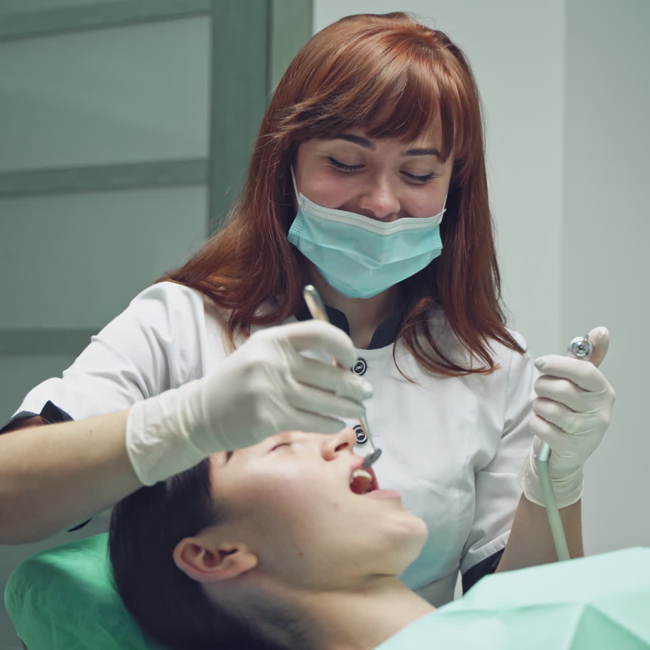 Young Female patient with open mouth examining dental inspection at dentist office. Dental clinic.