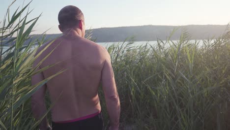 hombre caminando por el lago al atardecer