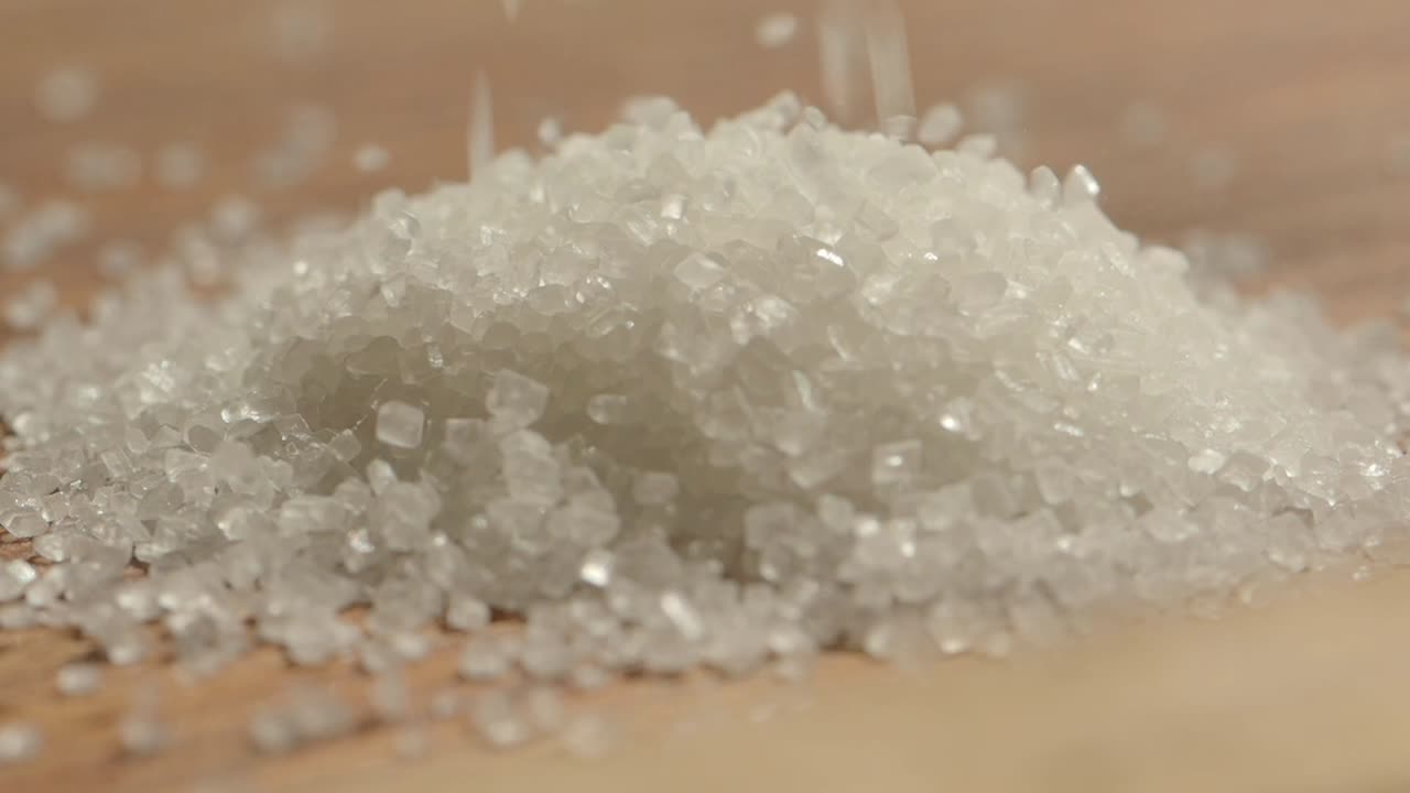 Close-up of White Sugar Crystals Being Poured