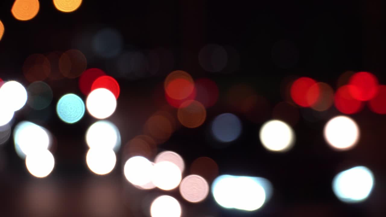 concepto abstracto. redondo colorido bokeh brilla de las luces de los coches en el atasco de tráfico en la calle de la ciudad. hermoso bokeh reluciente en el fondo oscuro borroso por la noche. refleja el estilo de vida solitario de la ciudad capital.