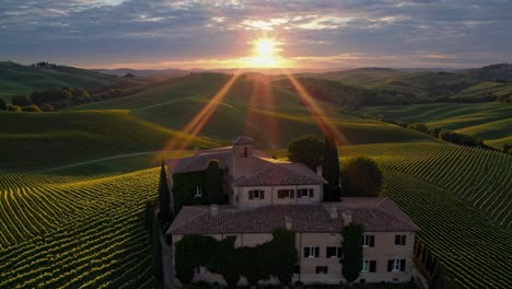 golden sunrise illuminates picturesque tuscan landscape, featuring a charming farmhouse nestled among rolling vineyards, creating a serene and idyllic scene in the heart of italy