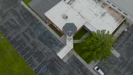 High-angle-approach-to-a-red-brick-church-on-a-foggy-day