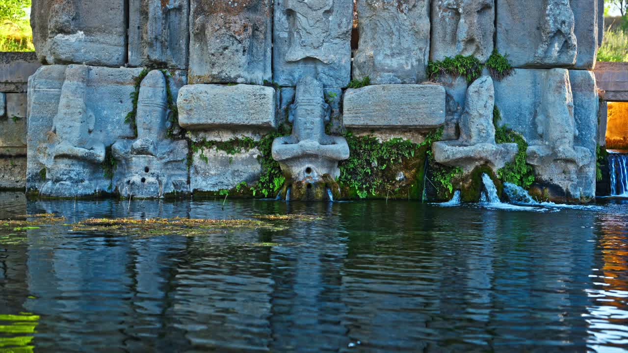 The ancient stone carvings of the Holy Water Temple, where water flows gently from the statues. 8k