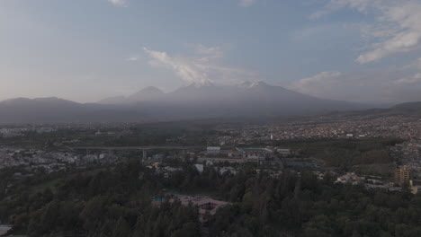 sideways moving drone shot above arequipa peru with view on the mountain near sunset time with clouds in the sky log