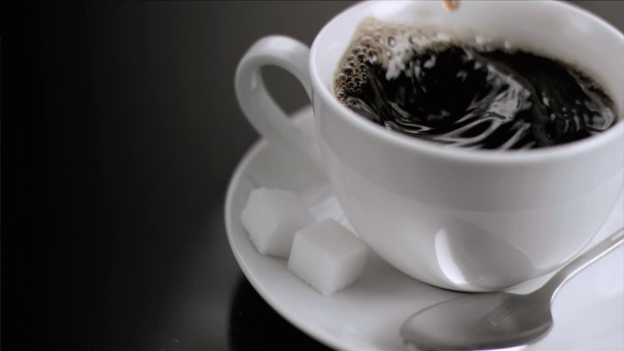 кубик сахара падает в супер медленном движении.