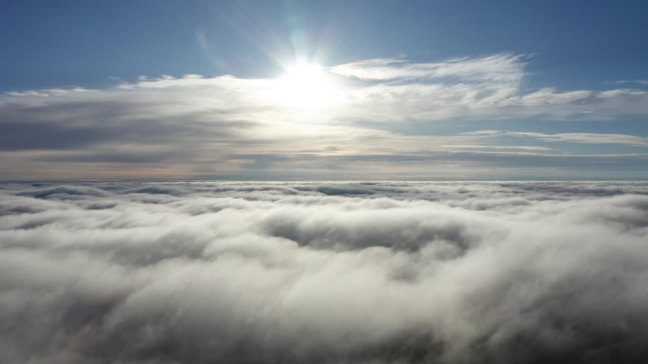 천천히 하늘을 향해 날아가는 빛나는, 구름 뒤의 태양, 구름 꼭대기처럼 하늘 위에