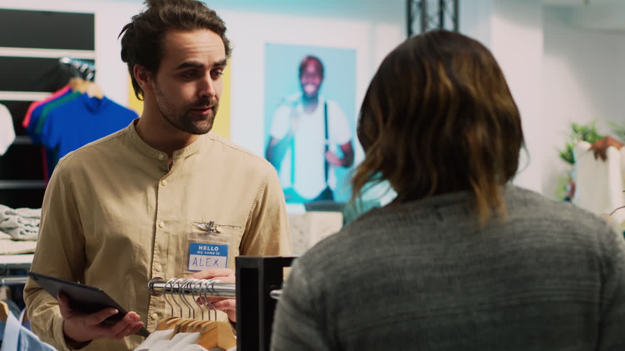 Clothing store employee assisting customer