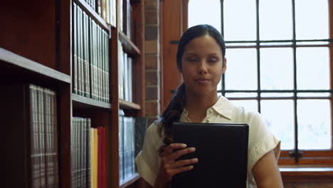 estudiante recogiendo un libro del estante en la biblioteca