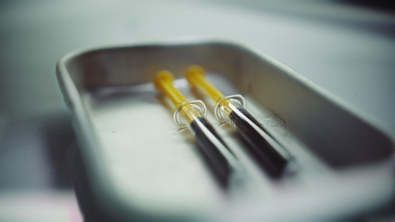 Syringes with a dark liquid on a medical tray