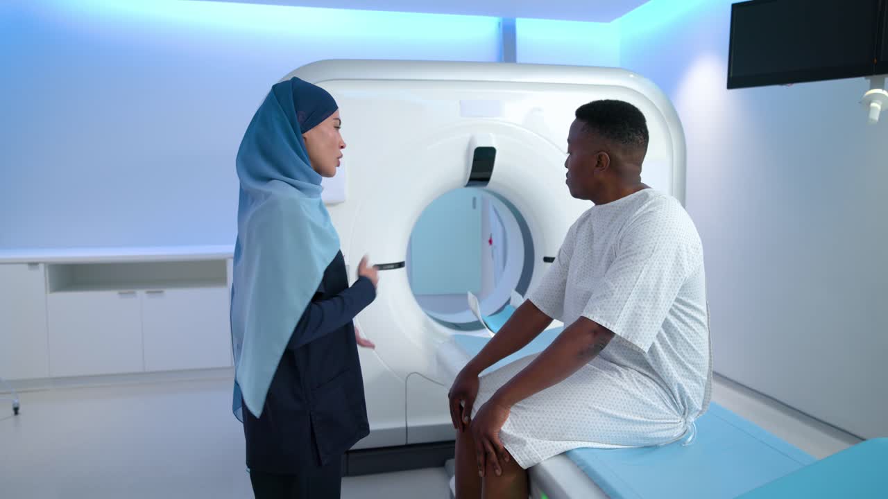 Tecnico donna che accompagna una paziente in camice nella sala TAC per una scansione programmata, mostrando respirazione e posizionamento