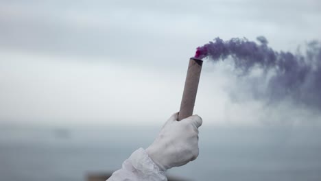 Person-in-protection-gloves-on-the-edge-of-the-roof-hold-smoke-stick