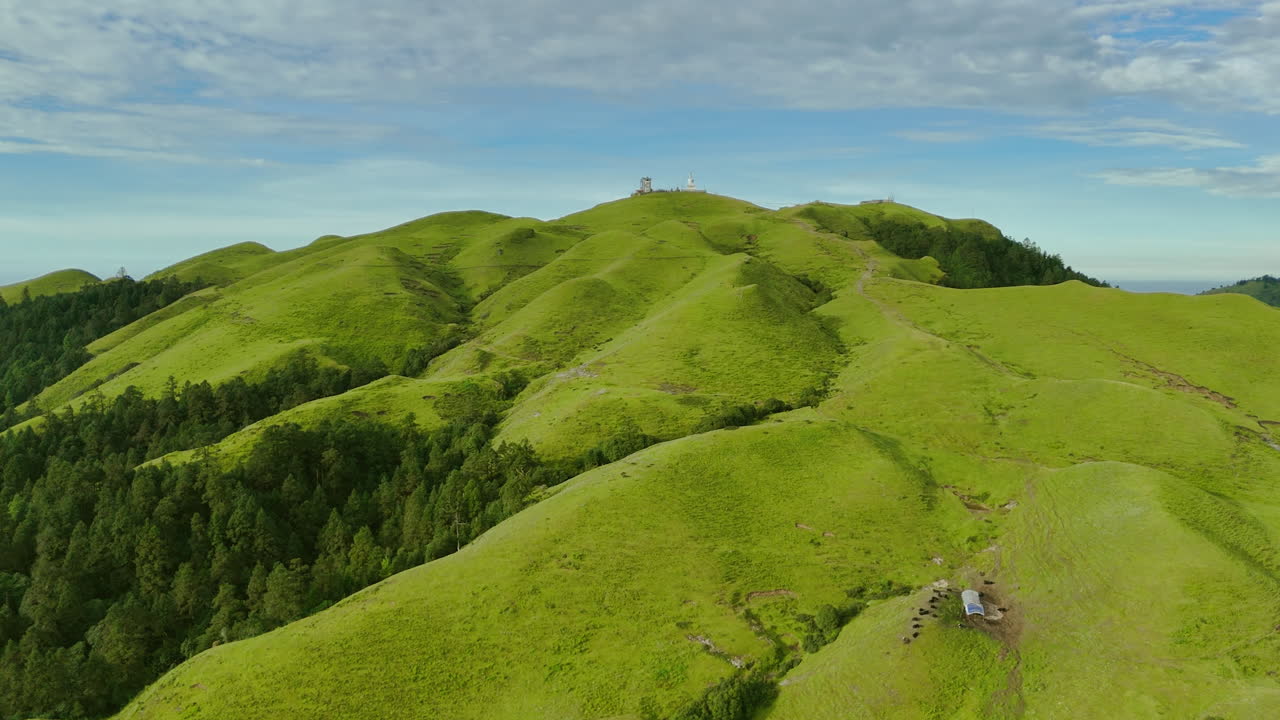 Drone shot captures Nepal’s landscape under clear blue sky, with clouds guiding trekking trails through forested hills and mountain landscapes, making it a top destination for tourists nature lovers