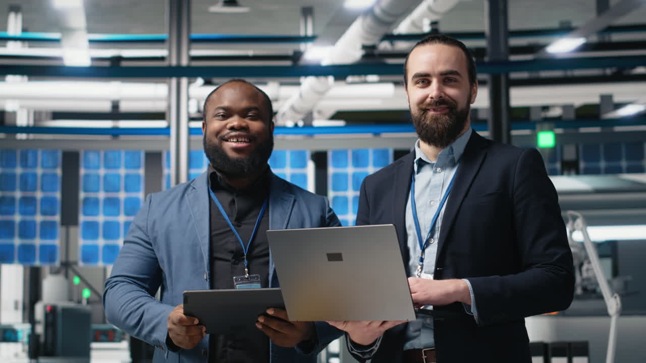 Ingeniører arbejder med bærbar computer og tablet i et industrielt miljø
