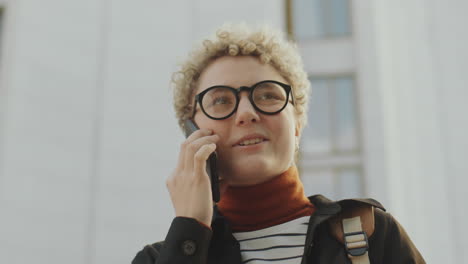 a young woman talks on a mobile phone outdoors