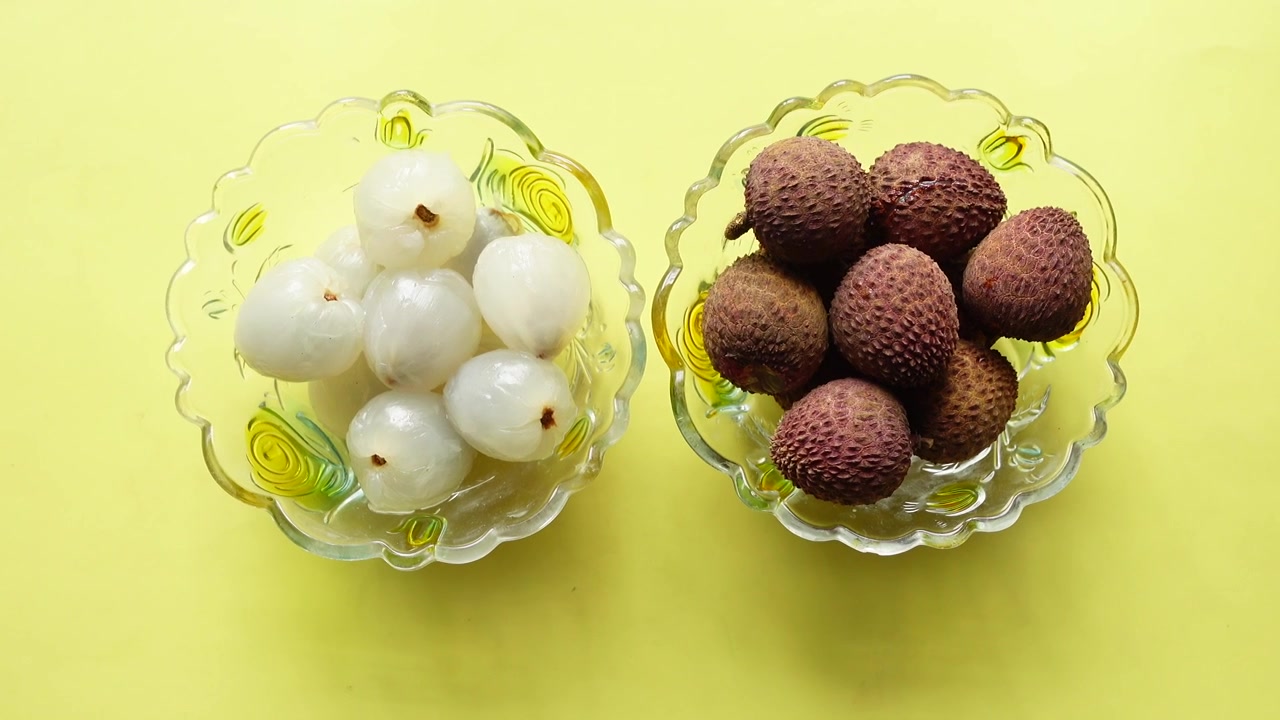 Litchi freschi in ciotole di vetro su sfondo giallo