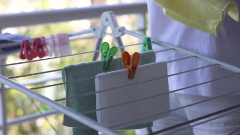 person hanging towels on a clothesline outdoors