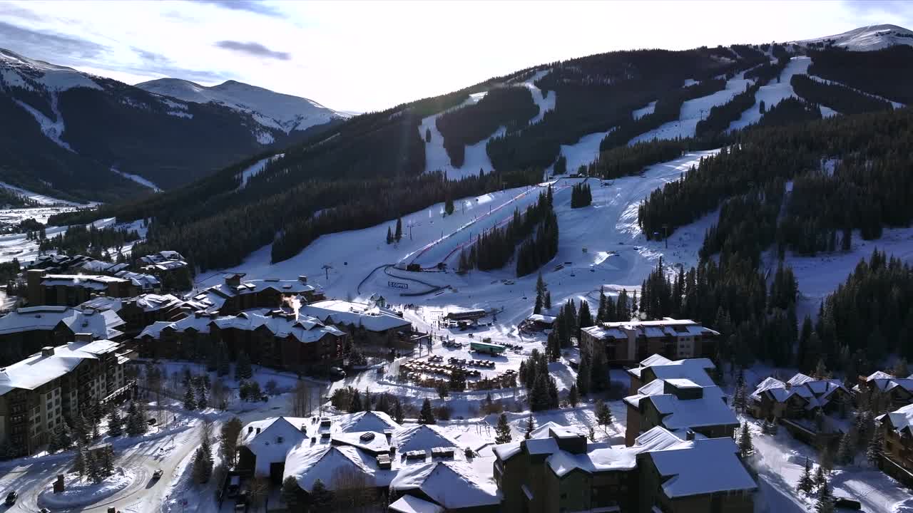Morning sunrise winter solstice Copper Mountain Resort aerial drone Center village chairlifts gondola Ikon Pass Alterra snowboarding snow ski riding trails December halfpipe trees forward reveal pan