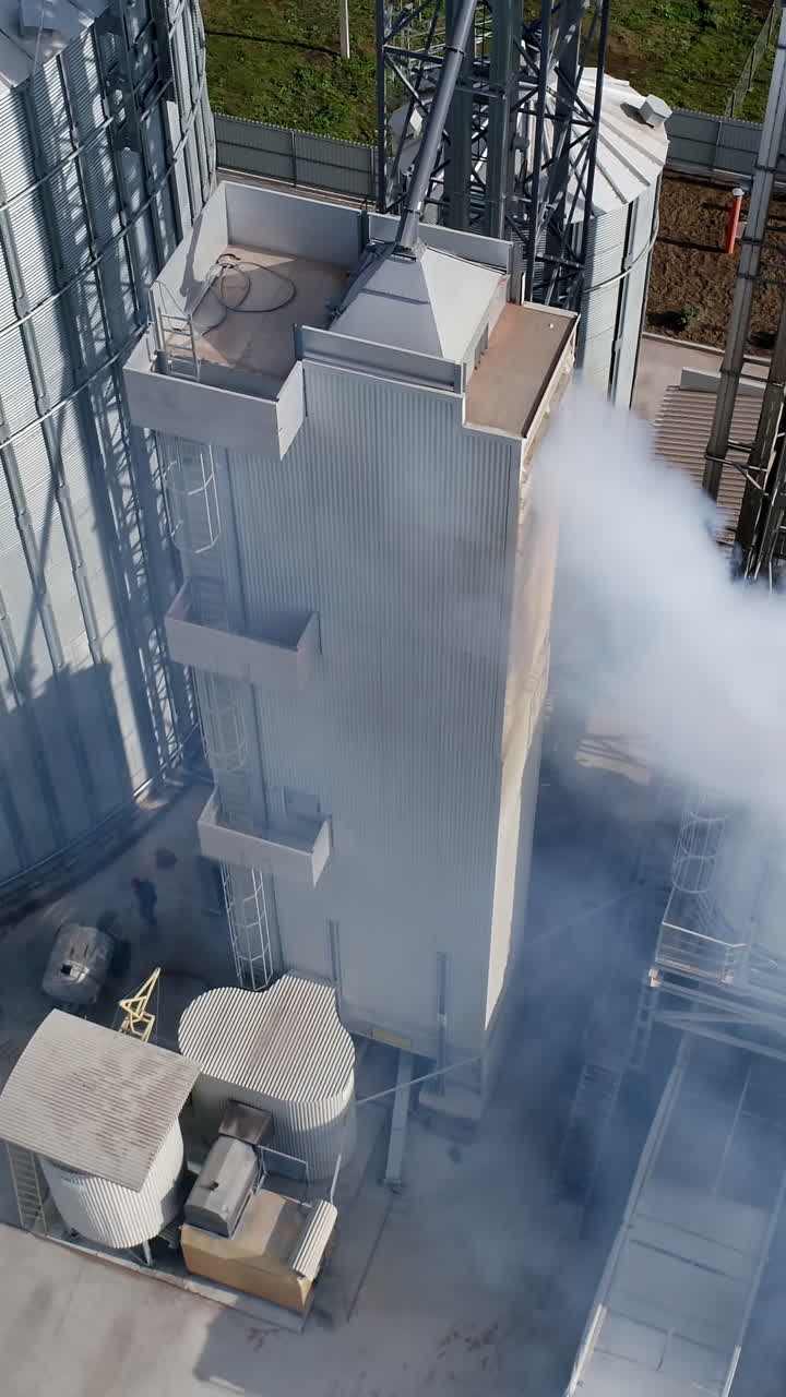 Big elevator metal construction. Modern industrial grain elevators. Aerial view. Vertical video