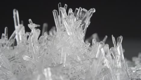 macro shot of clear salt crystals rotate against black background and sparkle