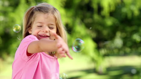 Kleines-Mädchen-Spielt-Mit-Seifenblasen-Im-Park