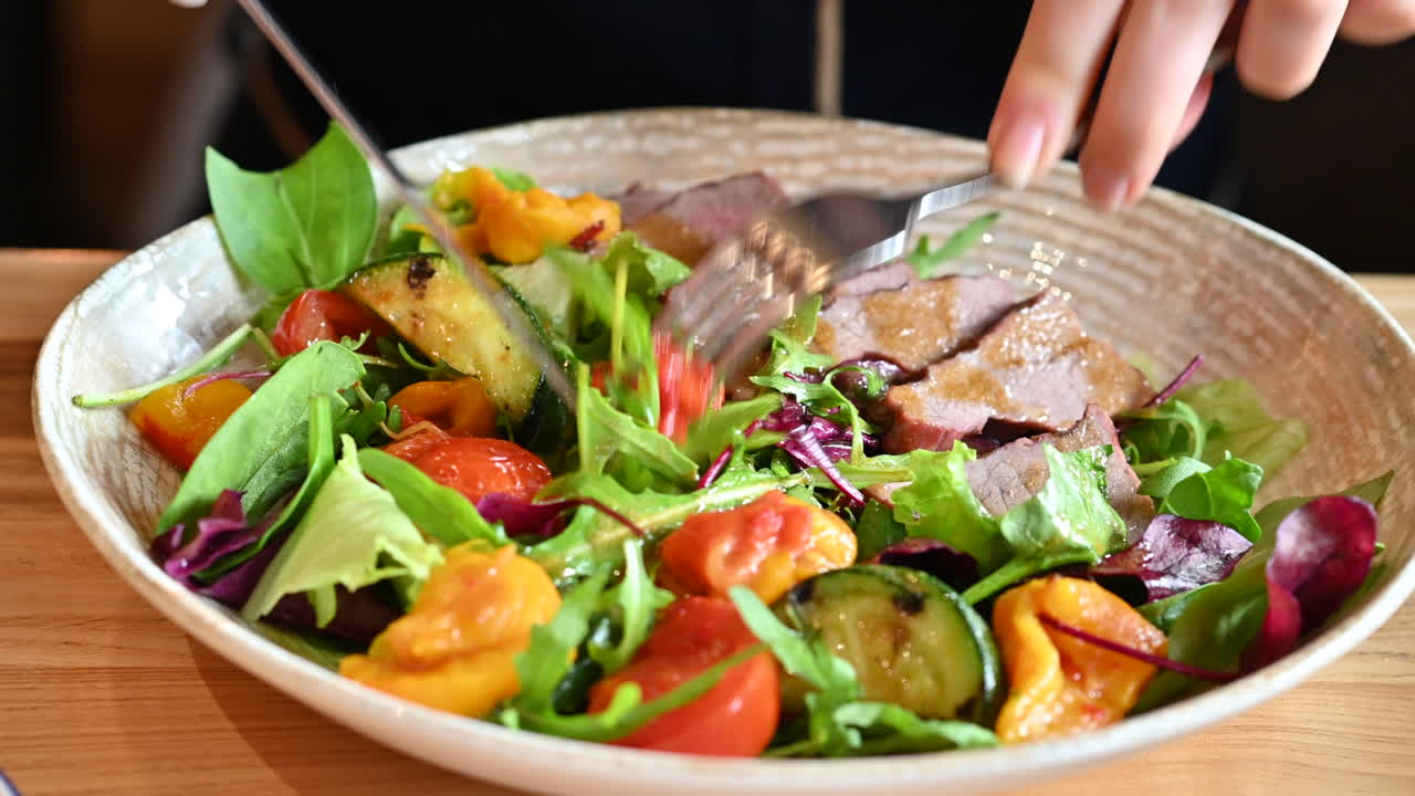 Close up of woman eating a salad at a restaurant