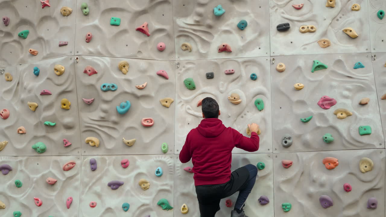 Free climber young man climbing on a climbing wall