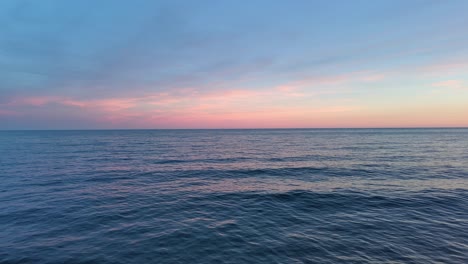 aerial shot on the waves of the sea in the orange sunset