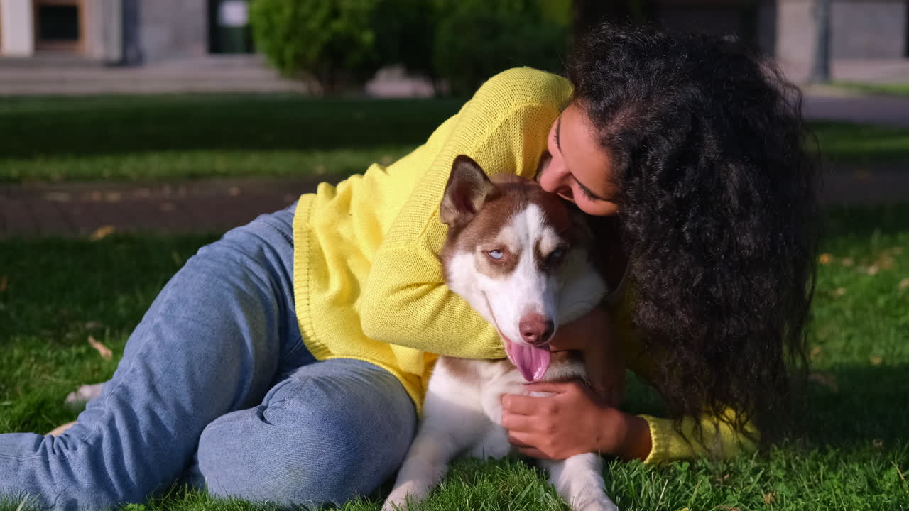 mujer abrazando a su perro husky en un parque