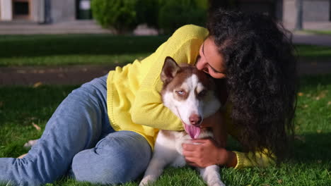 woman hugging her husky dog in a park