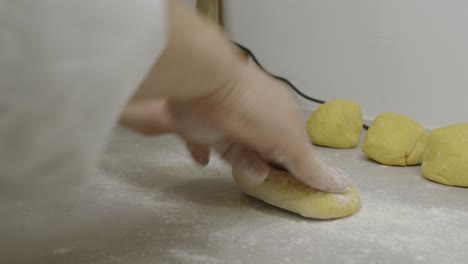 chef drops flour onto the pasta dough