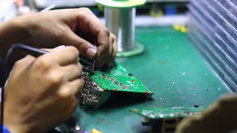 the engineer is soldering the inputs to the motherboard