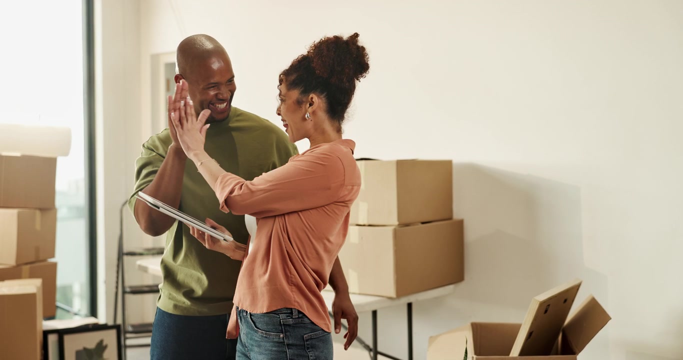 Happy Couple Celebrating Moving into New Home with Cardboard Boxes
