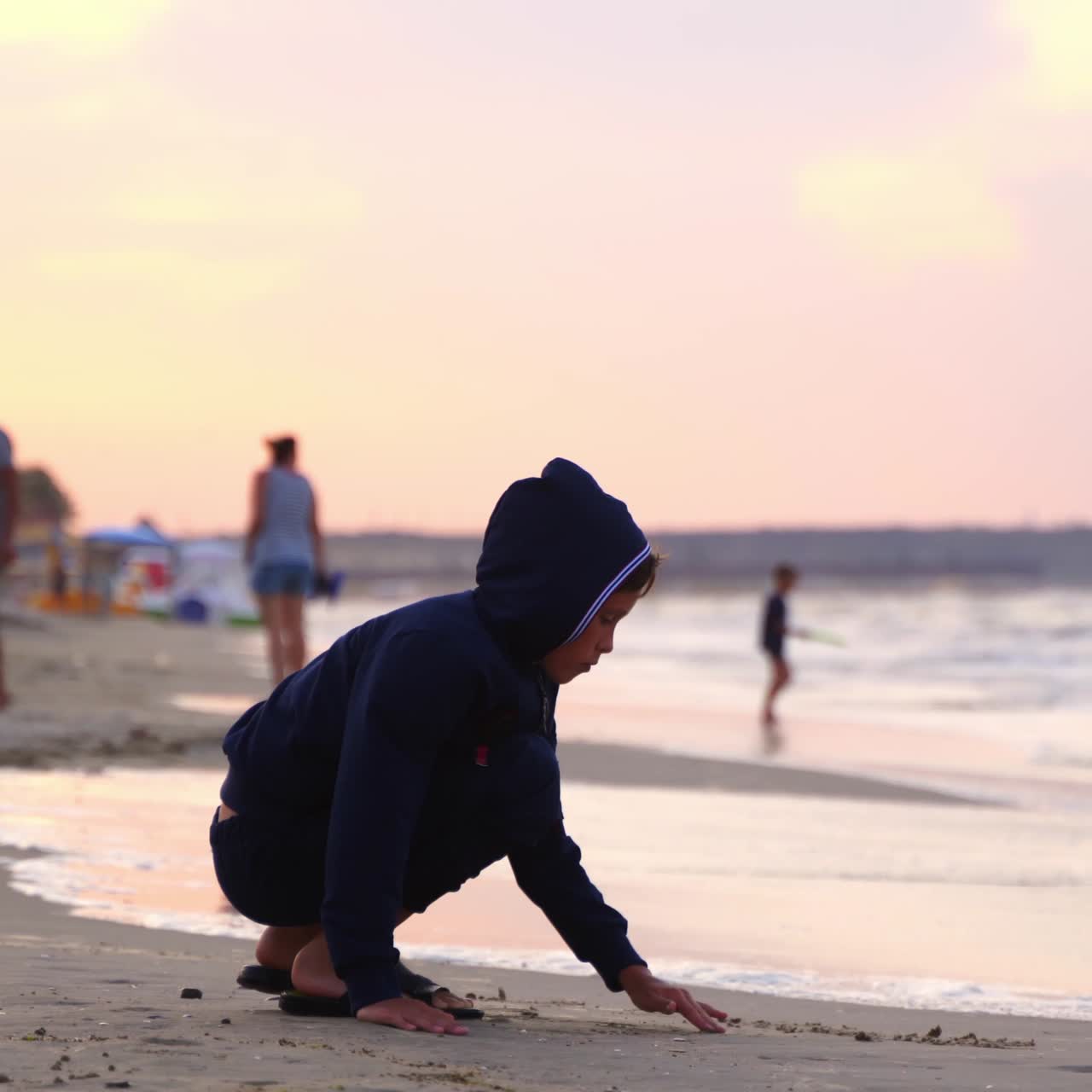 Boy writes words on sand