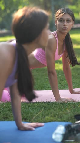 mother and daughter practicing yoga in a park