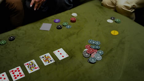 top view of hands of a a woman who bets her poker chips in the game