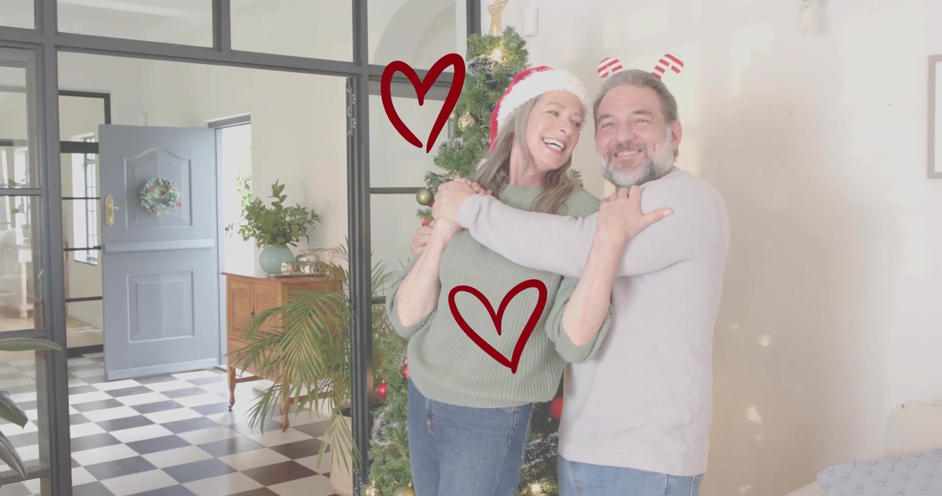 Pareja de ancianos tomados de la mano, bailando alrededor del árbol de Navidad con corazones flotando para marketing navideño.