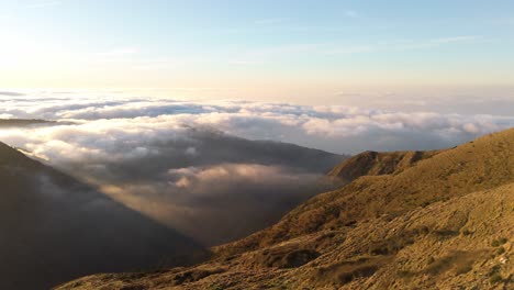 Colinas-Doradas-Con-Un-Manto-De-Nubes-Debajo-Al-Atardecer-En-Génova,-Liguria,-Italia,-Vista-Aérea