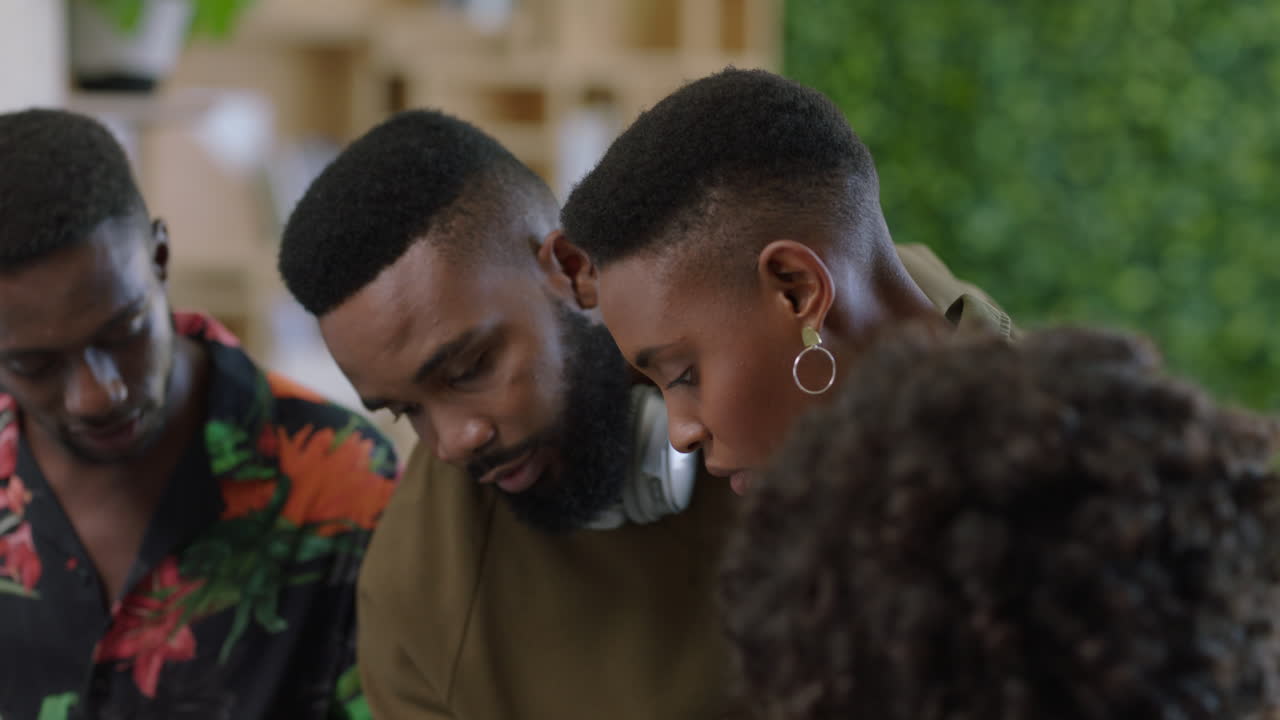 전문적인 아프리카계 미국인 사업가들이 아이디어를 공유하는 창의적인 팀 사무실 관리자 남자가 동료들과 협력하여 트렌디한 직장에서 함께 일합니다.