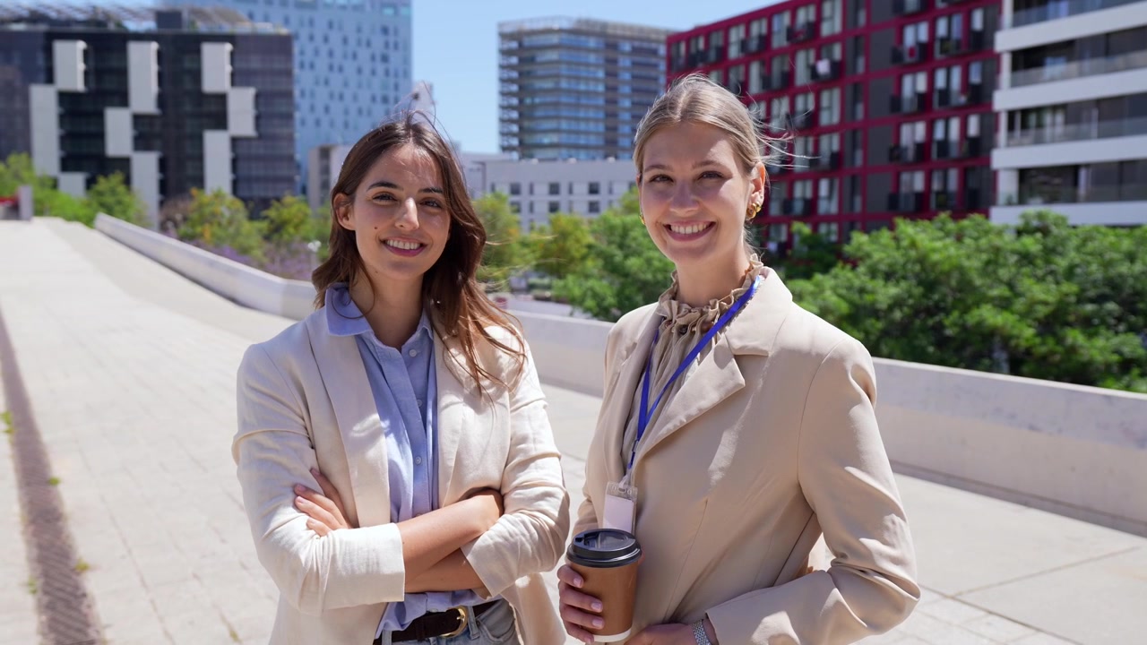 Two Confident Businesswomen Smiling Outdoors in a Modern City